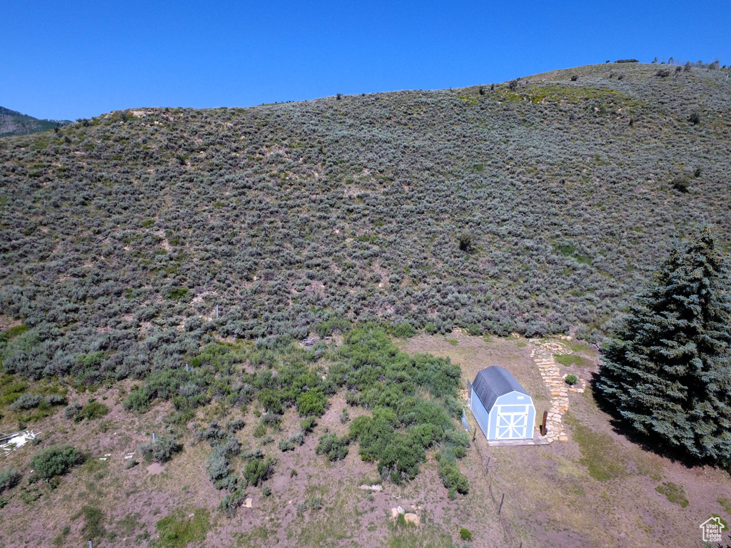 Exterior space featuring a storage unit, a mountain view, and an outbuilding