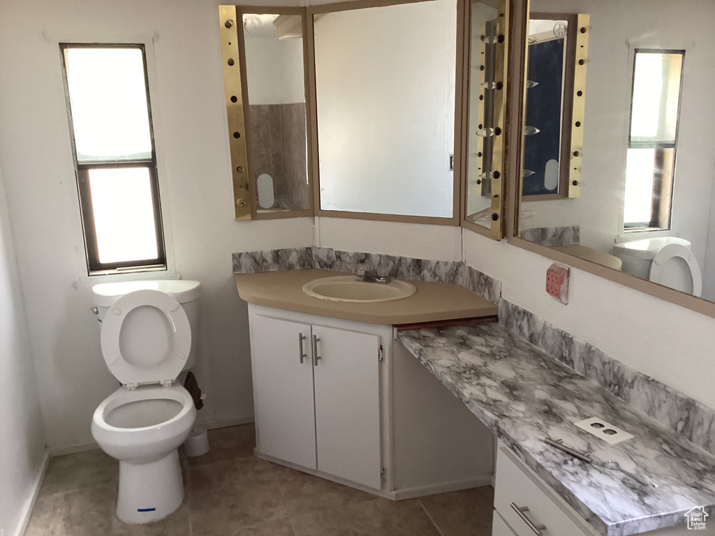 Bathroom featuring tile patterned floors, toilet, and baseboards