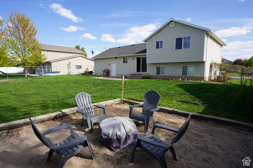 Back of property featuring a patio, a yard, entry steps, and a fenced backyard