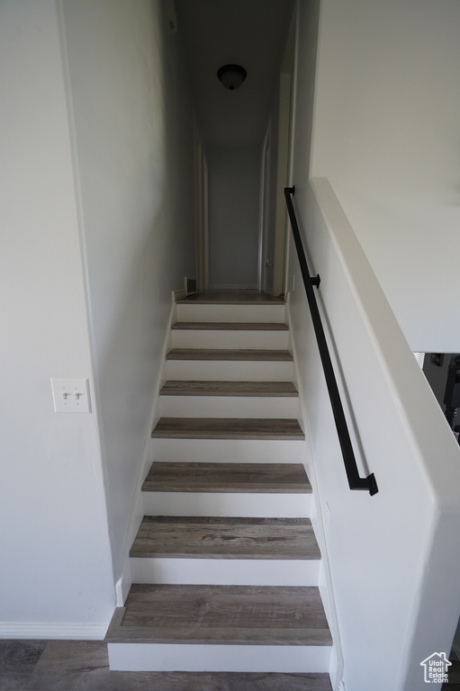 Stairs featuring wood finished floors and baseboards
