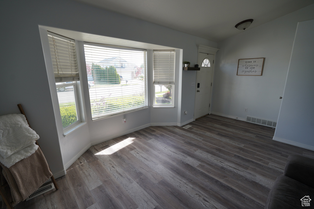 Entrance foyer with baseboards, visible vents, and wood finished floors