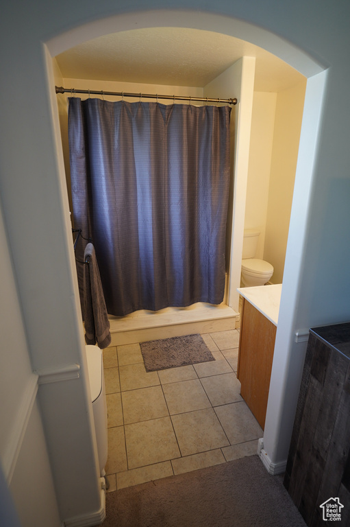 Full bathroom featuring toilet, vanity, and tile patterned flooring