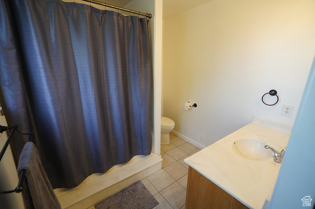 Full bath with toilet, tile patterned flooring, vanity, and a shower with shower curtain