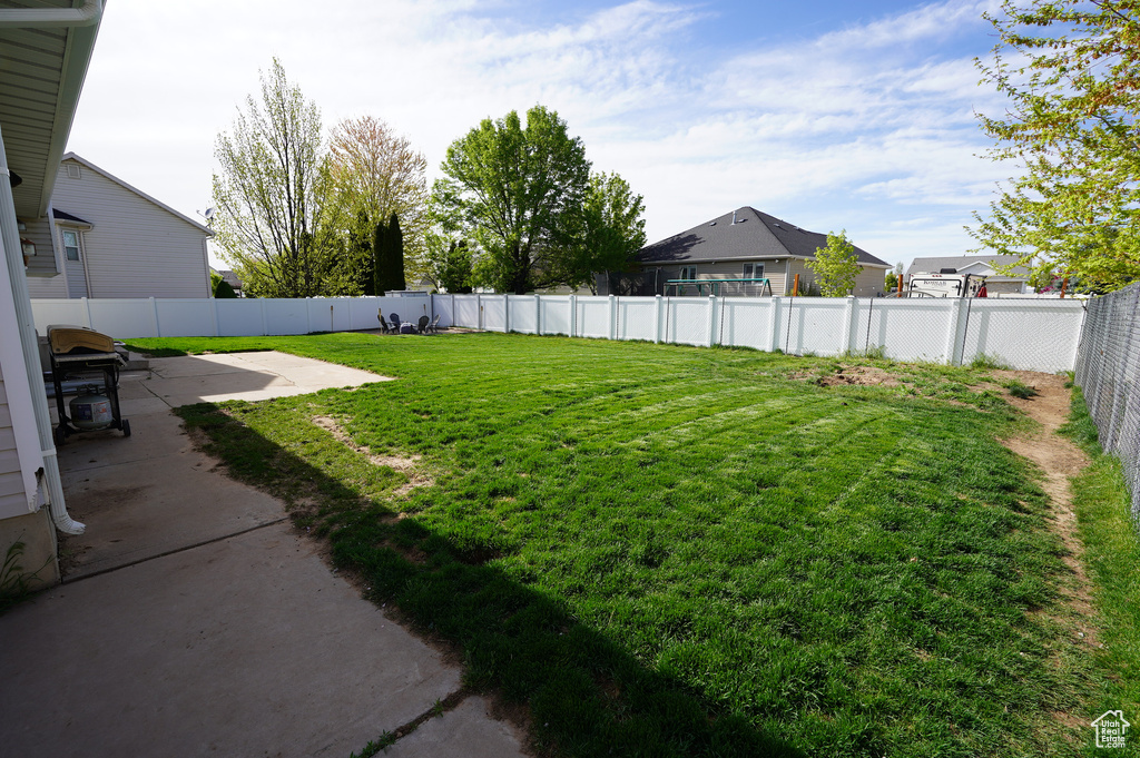 View of yard with a fenced backyard and a patio area