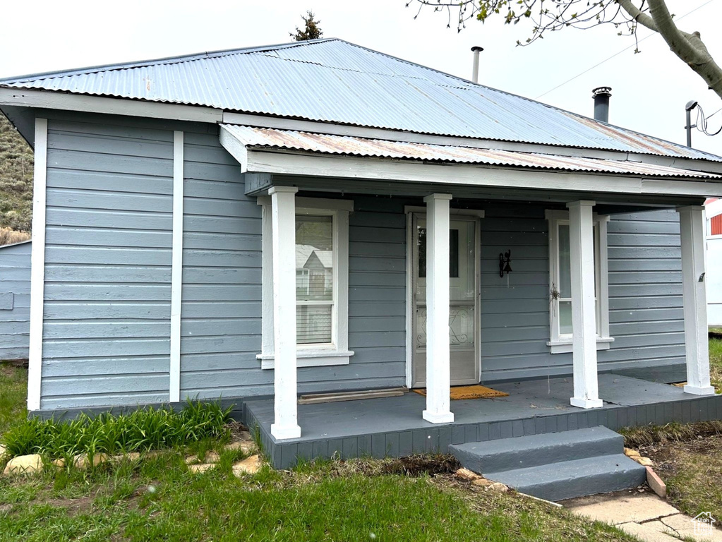 View of front facade with a porch and metal roof