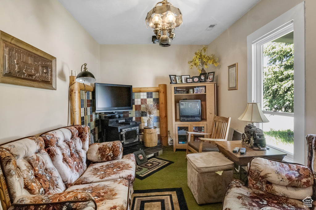 Living area featuring visible vents, plenty of natural light, carpet flooring, and a notable chandelier