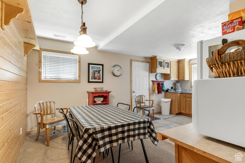 Dining space with visible vents, light colored carpet, and plenty of natural light