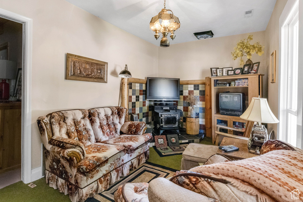 Living area featuring carpet, visible vents, a wealth of natural light, and a chandelier
