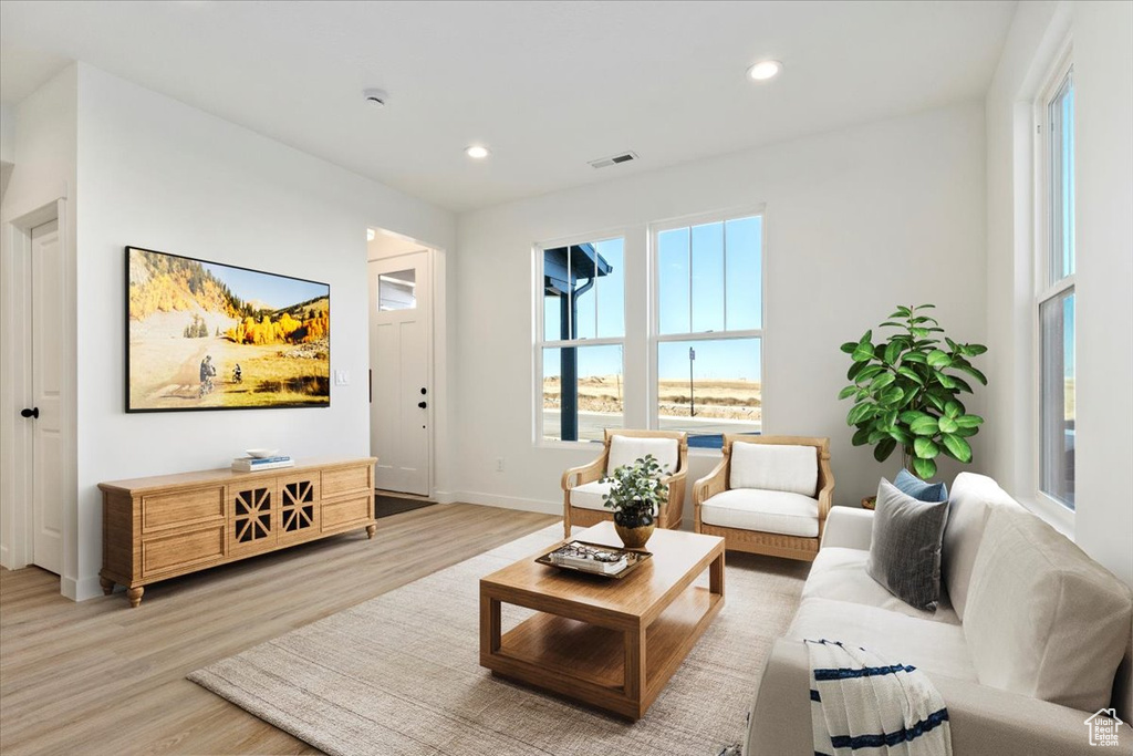 Living room with light wood-type flooring, baseboards, visible vents, and recessed lighting
