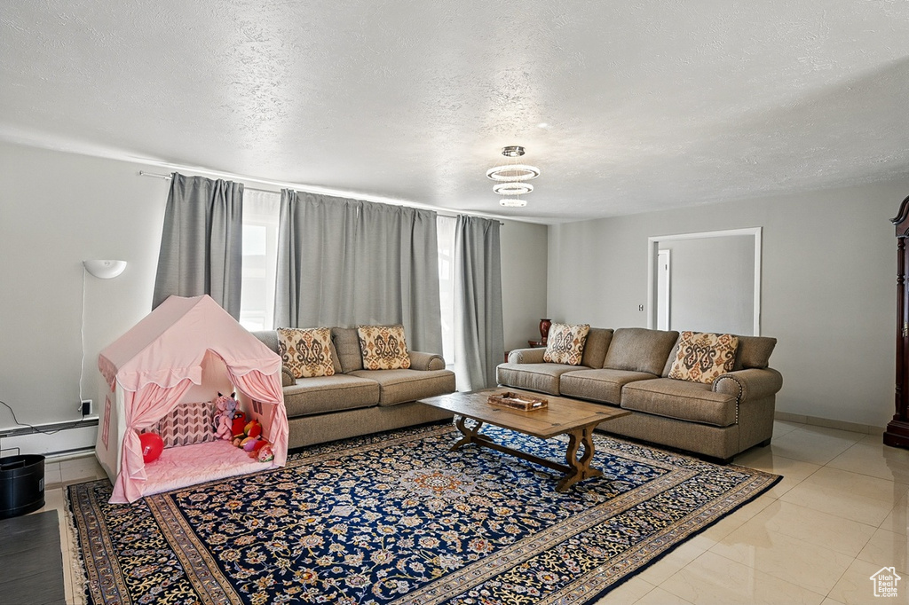 Living room with a baseboard radiator and a textured ceiling