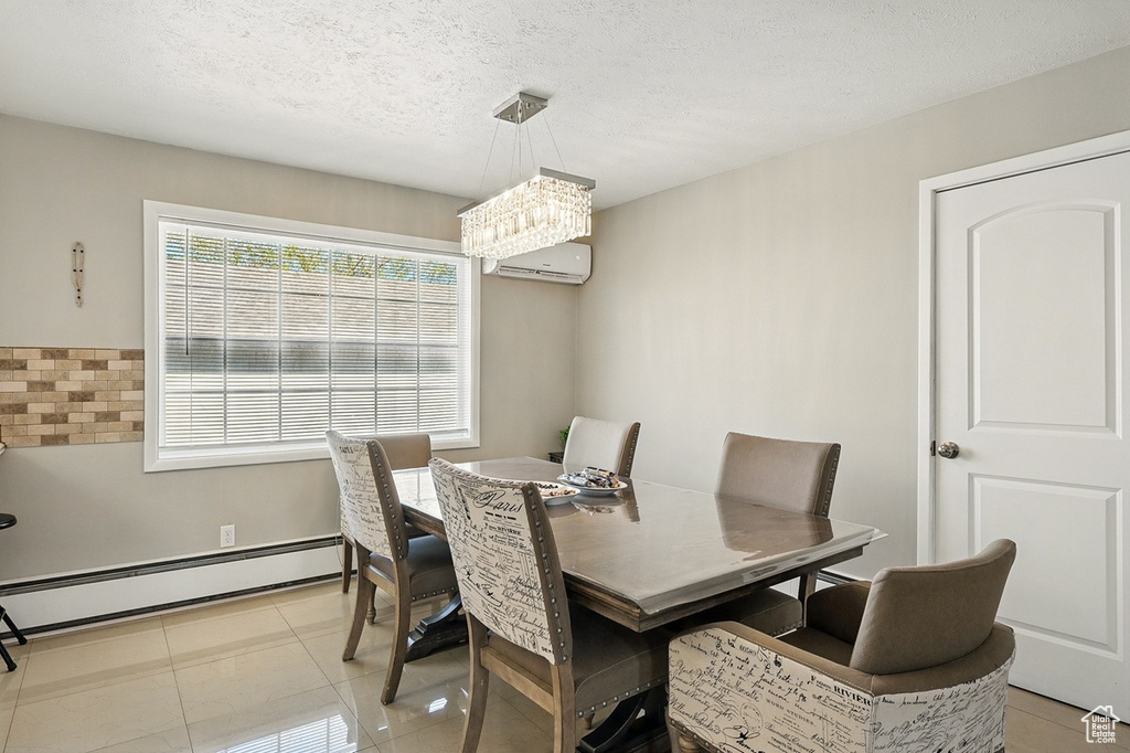 Dining space featuring a baseboard radiator, light tile patterned floors, a notable chandelier, and a wall unit AC