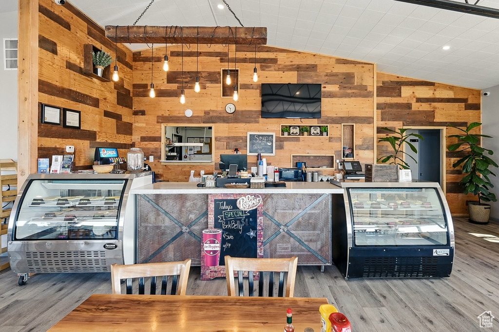 Interior space with wooden walls, lofted ceiling, and wood finished floors