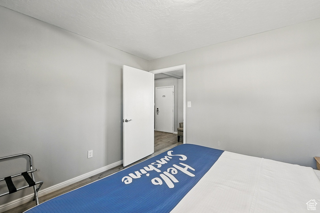 Bedroom with wood finished floors and baseboards