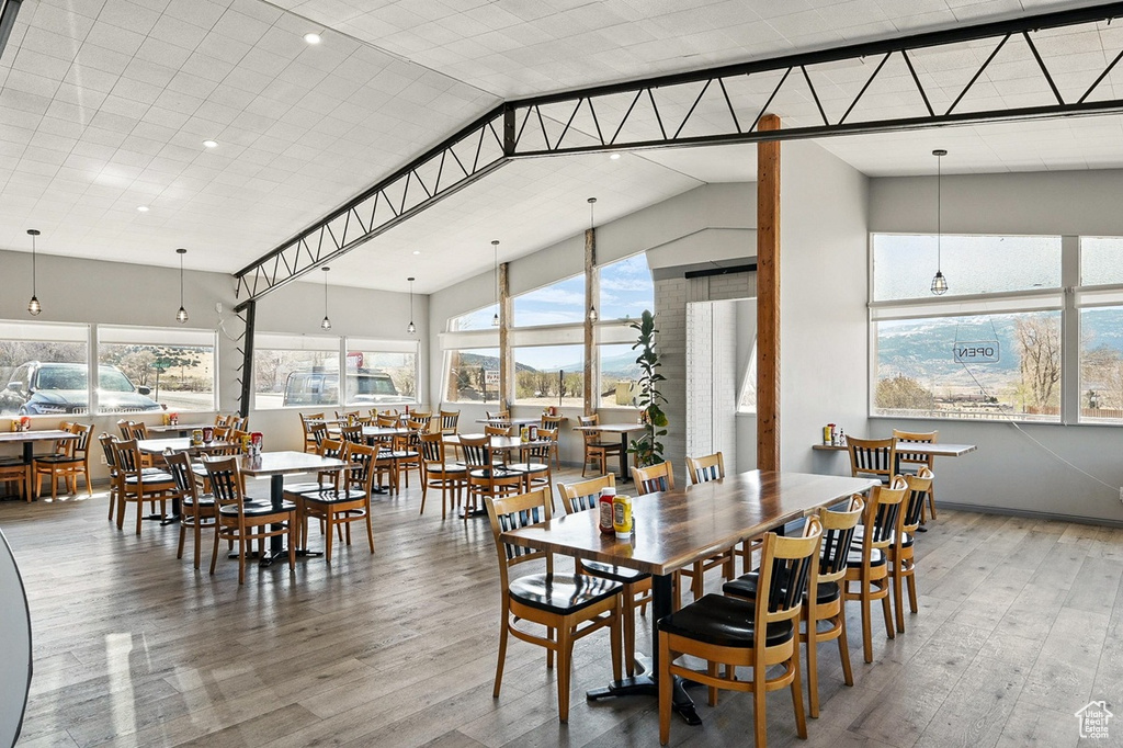 Dining room with high vaulted ceiling, wood finished floors, and recessed lighting
