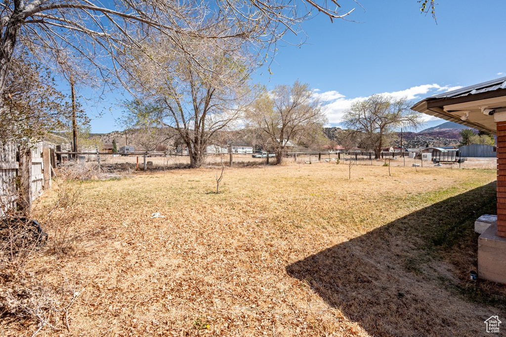 View of yard with fence and a mountain view