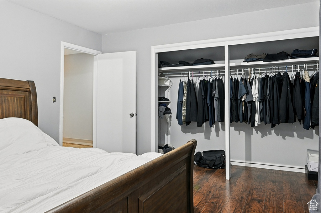 Bedroom featuring baseboard heating, baseboards, and wood finished floors