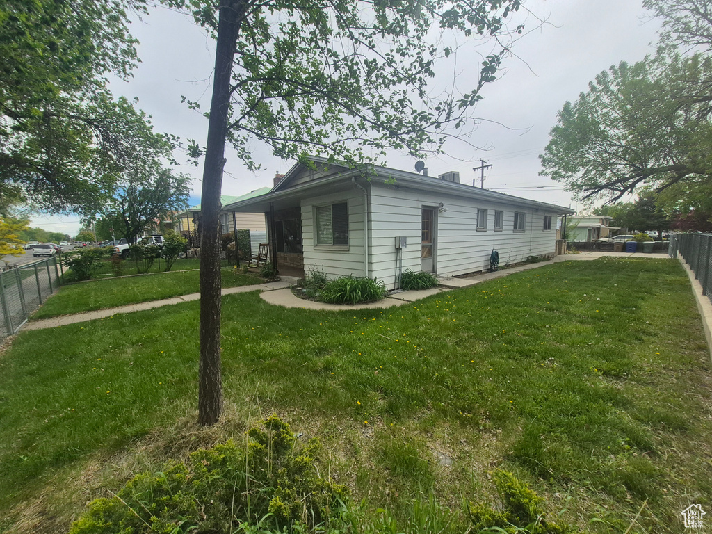 View of side of property featuring a yard and a fenced backyard