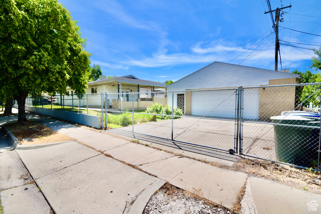 Ranch-style home featuring an outdoor structure, a gate, central AC, and a fenced front yard