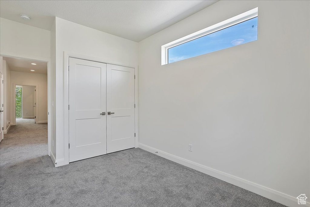 Unfurnished bedroom featuring a closet, baseboards, and carpet floors