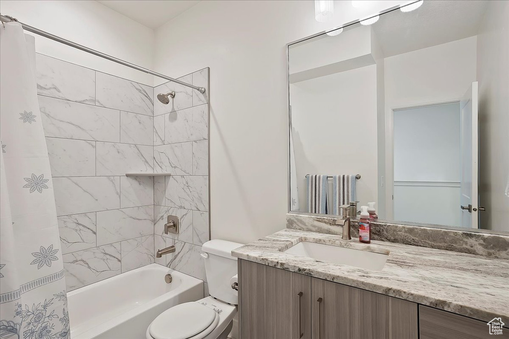 Full bath with shower / bathtub combination with curtain, toilet, and vanity