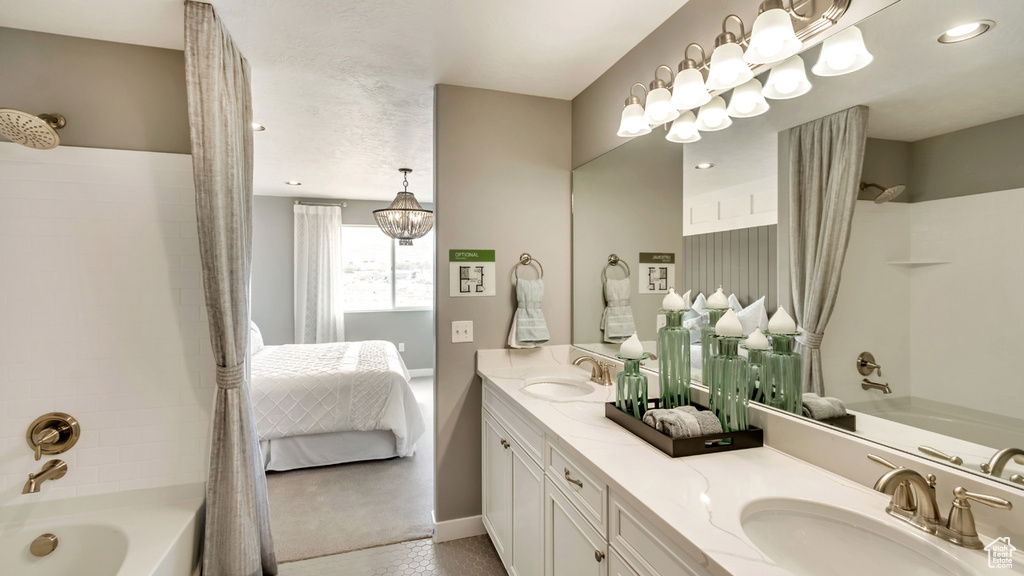 Ensuite bathroom with baseboards, shower / bath combo, double vanity, and a sink