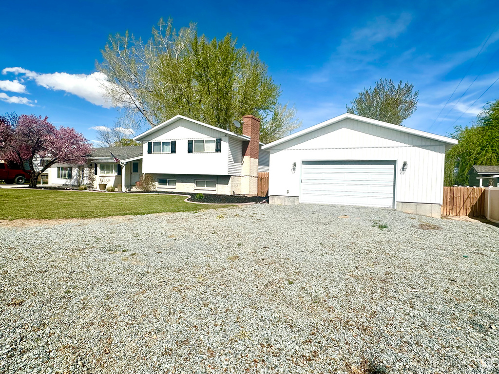 Split level home with fence, a front yard, and a garage