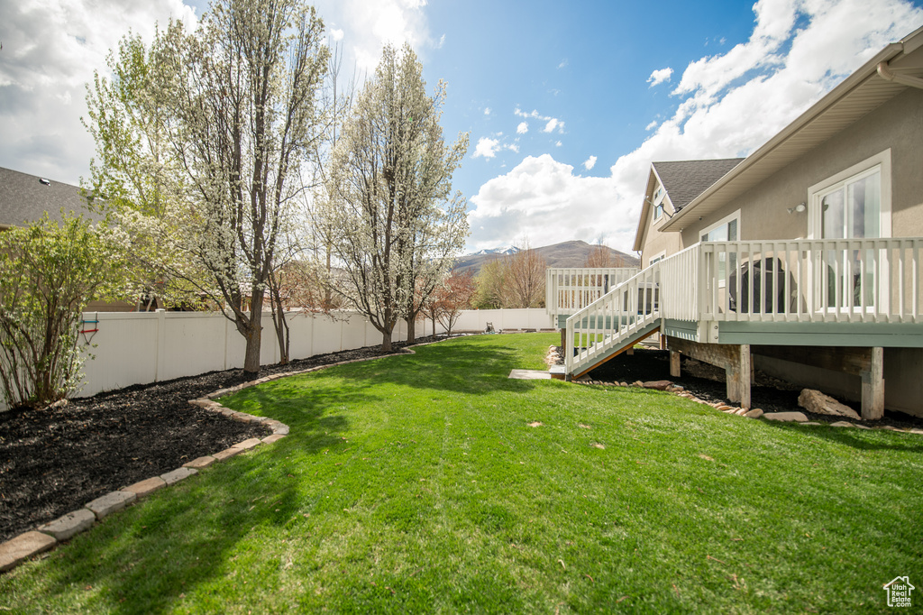 View of yard with a fenced backyard, a wooden deck, and stairs