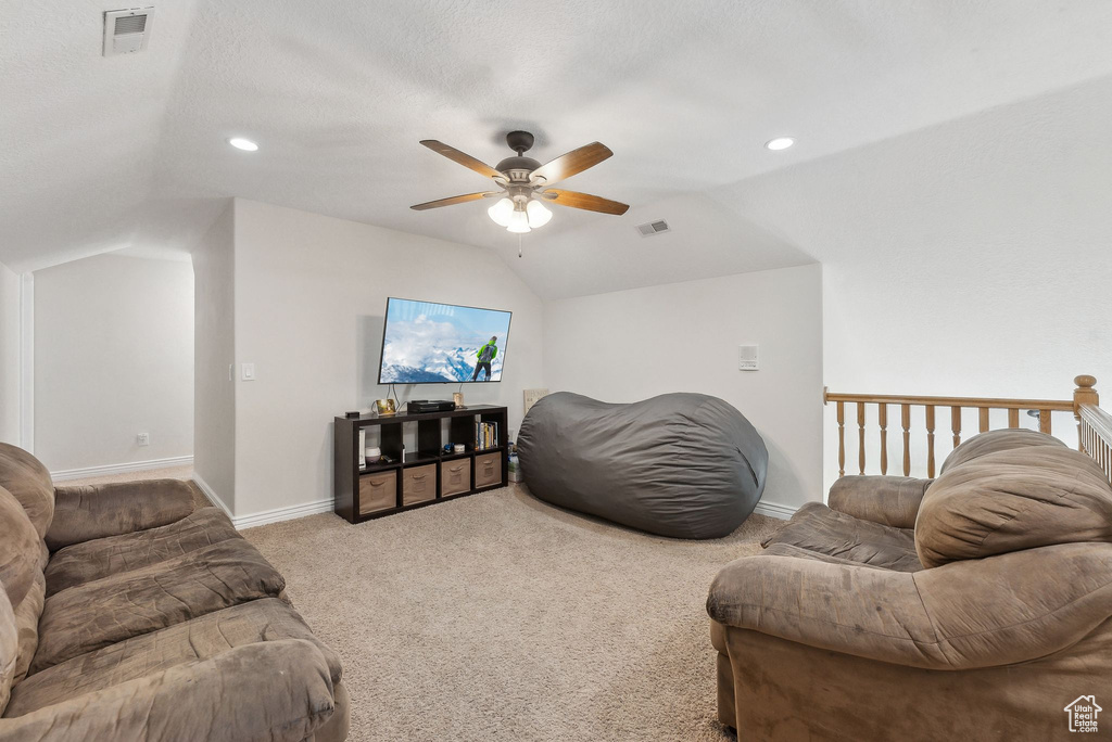 Living area featuring carpet floors, lofted ceiling, and visible vents