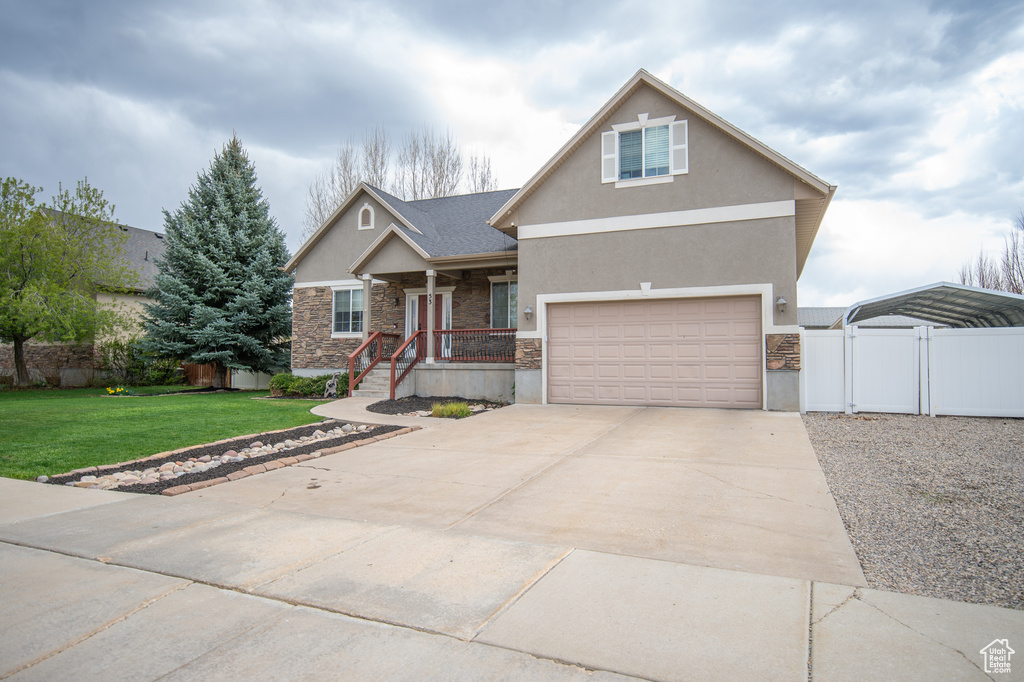 Craftsman house with driveway, a gate, stucco siding, fence, and a front lawn