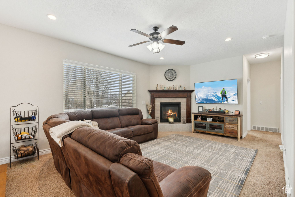 Living room with recessed lighting, visible vents, ceiling fan, a tile fireplace, and baseboards