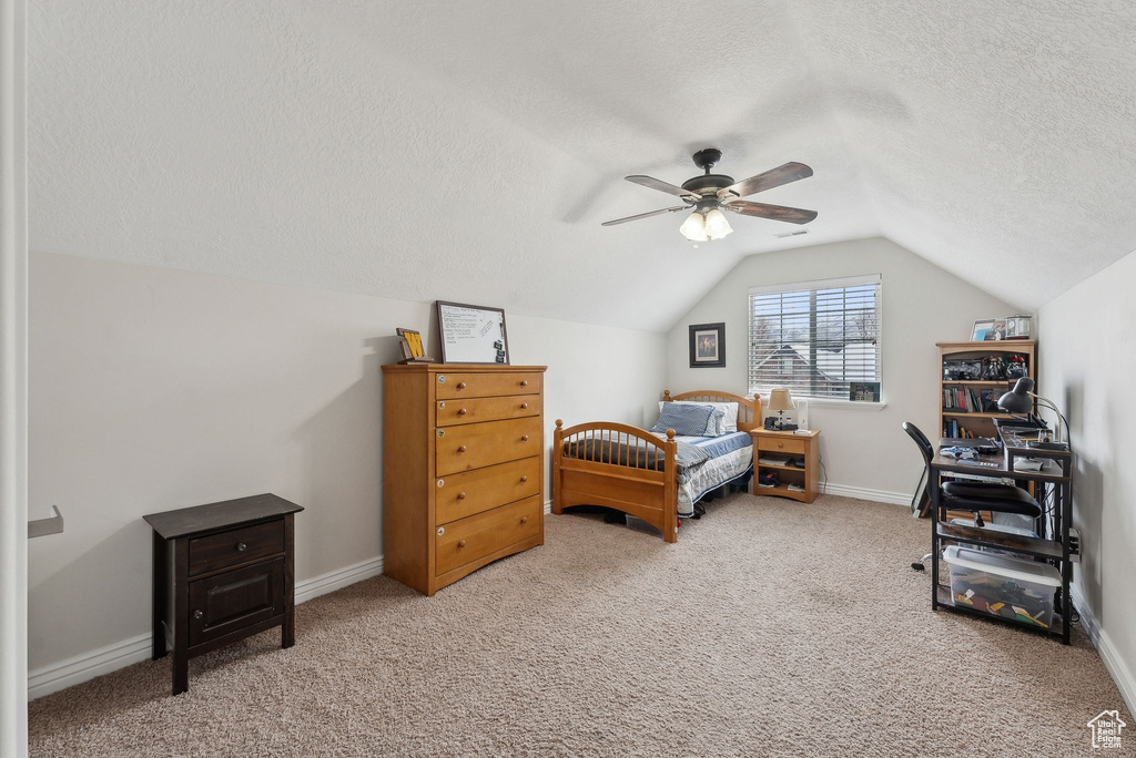 Bedroom featuring lofted ceiling, carpet flooring, ceiling fan, a textured ceiling, and baseboards
