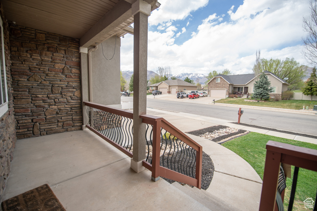 Balcony featuring a residential view, a mountain view, and covered porch