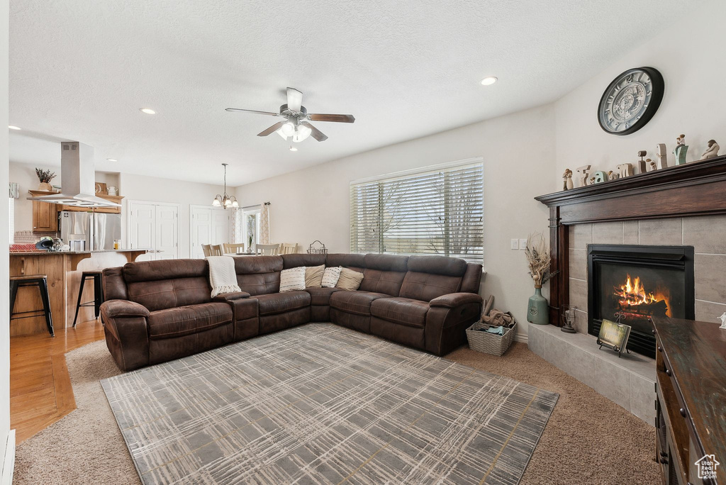Living room featuring a textured ceiling, a tile fireplace, and recessed lighting
