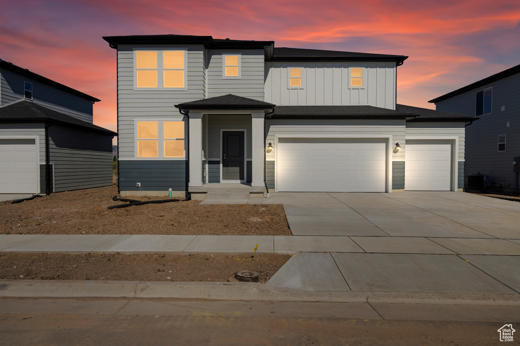 View of front facade with a garage, board and batten siding, and concrete driveway