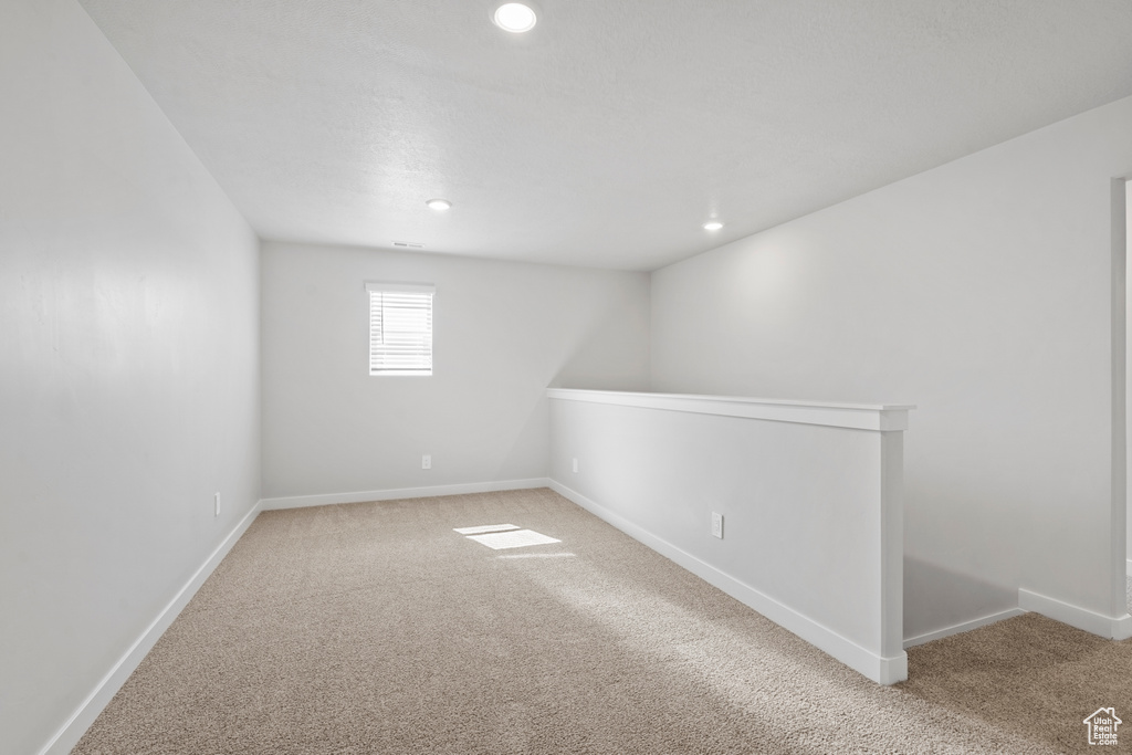 Basement with baseboards, light carpet, and recessed lighting