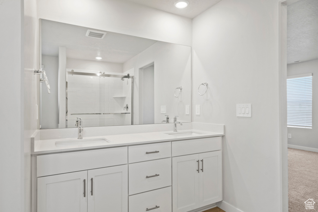 Full bathroom featuring baseboards, visible vents, a shower stall, and a sink