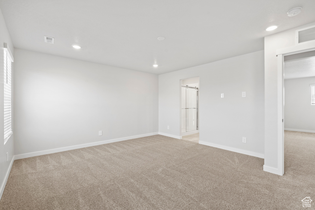Empty room with light colored carpet, recessed lighting, baseboards, and visible vents