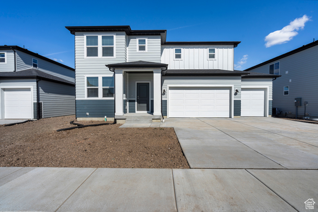 View of front of house with a garage, board and batten siding, and concrete driveway