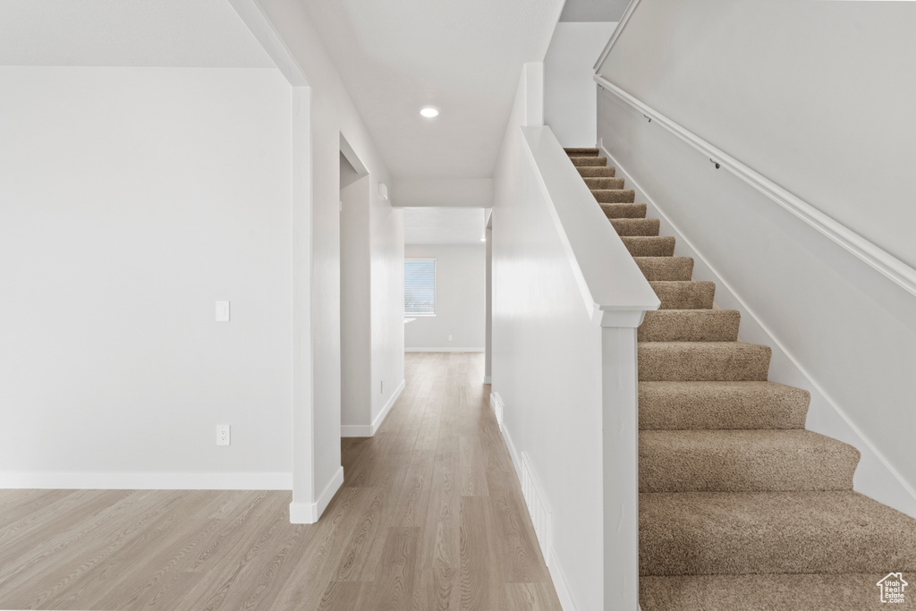 Stairway featuring recessed lighting, baseboards, and wood finished floors