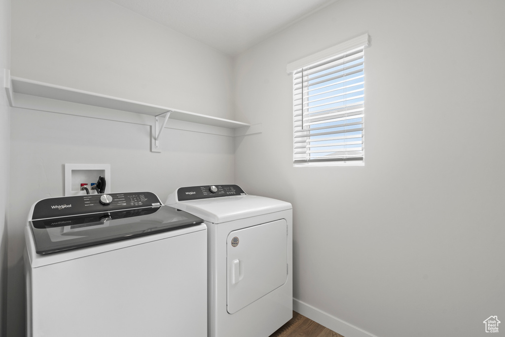 Washroom with baseboards, laundry area, washing machine and dryer, and dark wood-style flooring