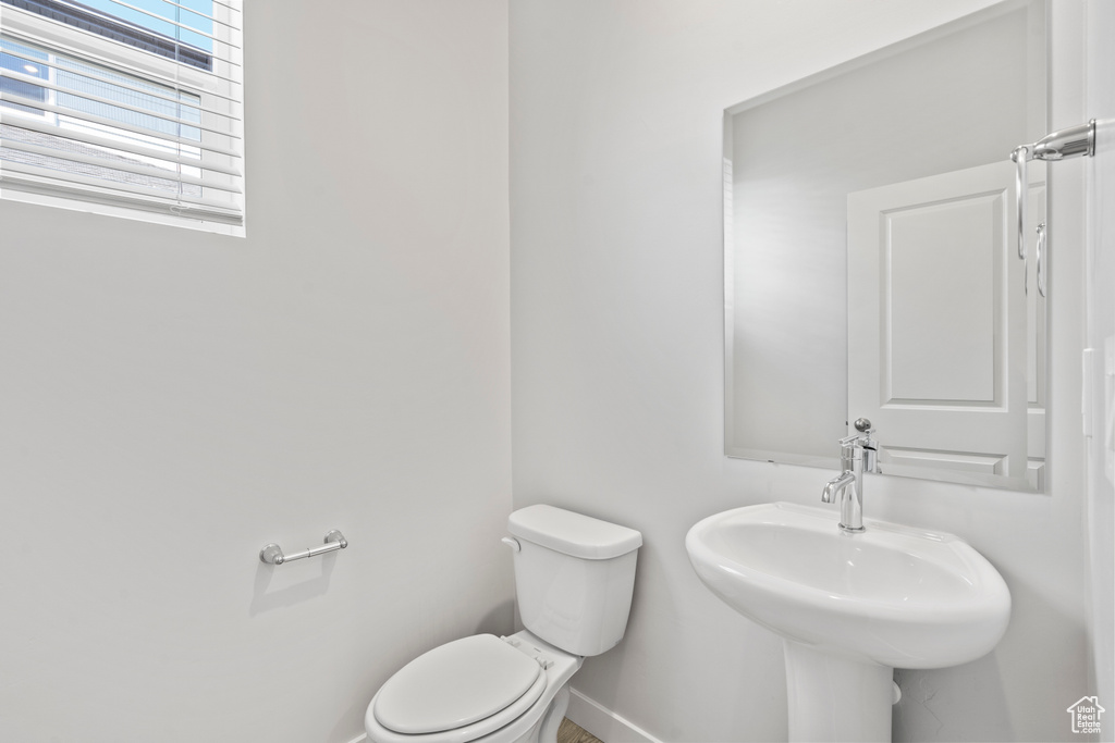 Bathroom featuring a sink, baseboards, and toilet