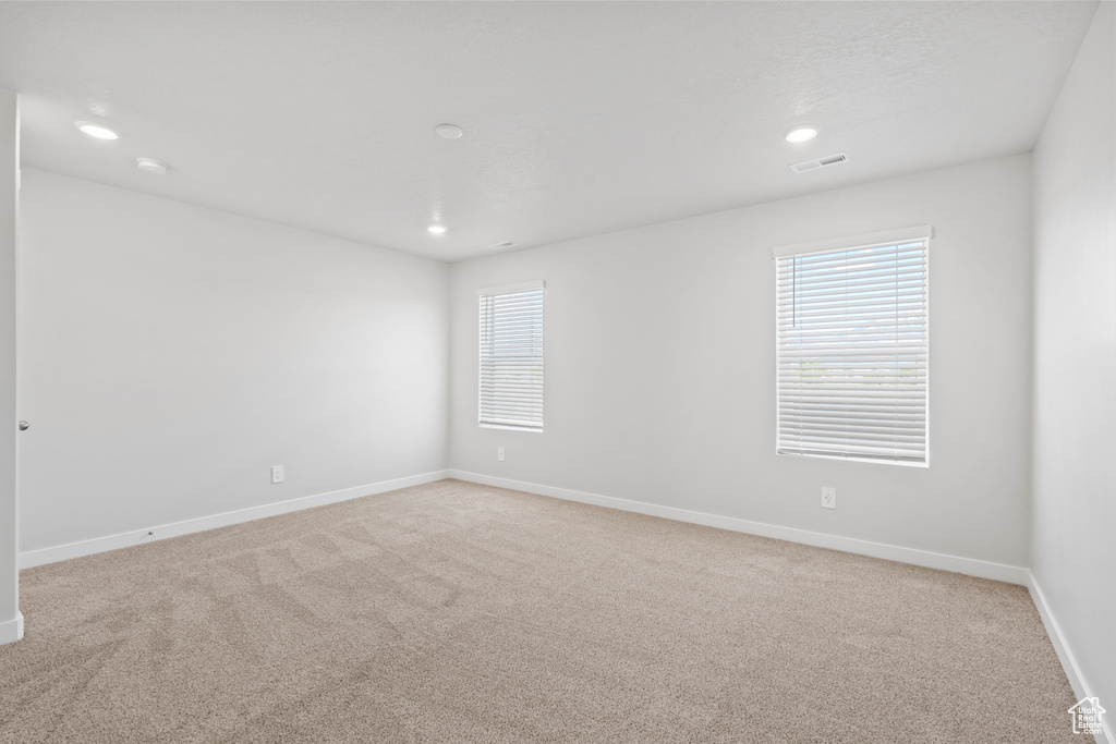 Carpeted spare room featuring recessed lighting, baseboards, and visible vents