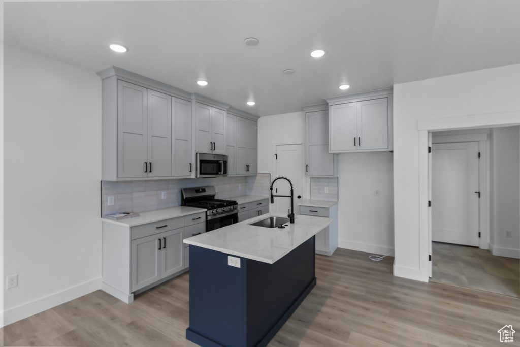 Kitchen with a sink, backsplash, stainless steel appliances, and baseboards