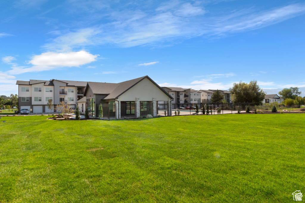 Back of house featuring a lawn and a residential view