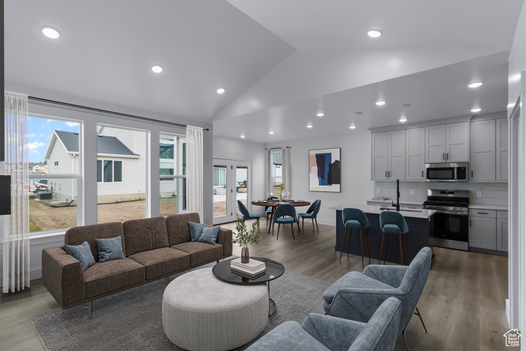 Living area featuring wood finished floors, recessed lighting, and high vaulted ceiling