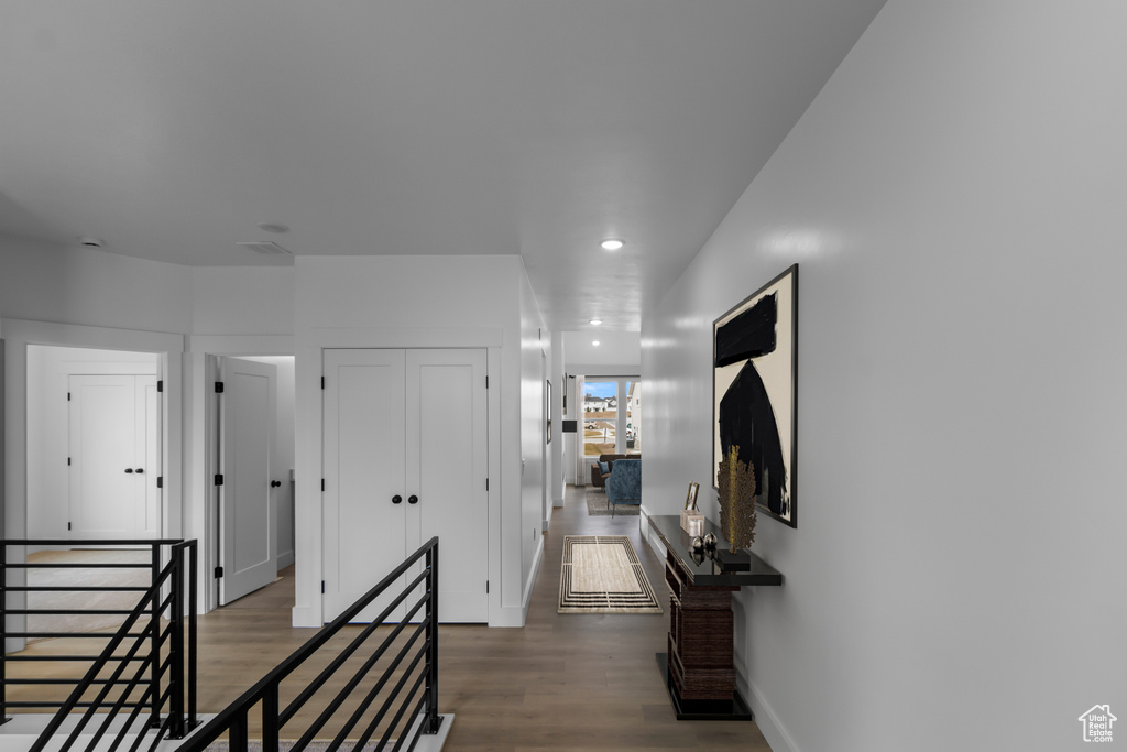Hallway featuring baseboards, recessed lighting, wood finished floors, and an upstairs landing
