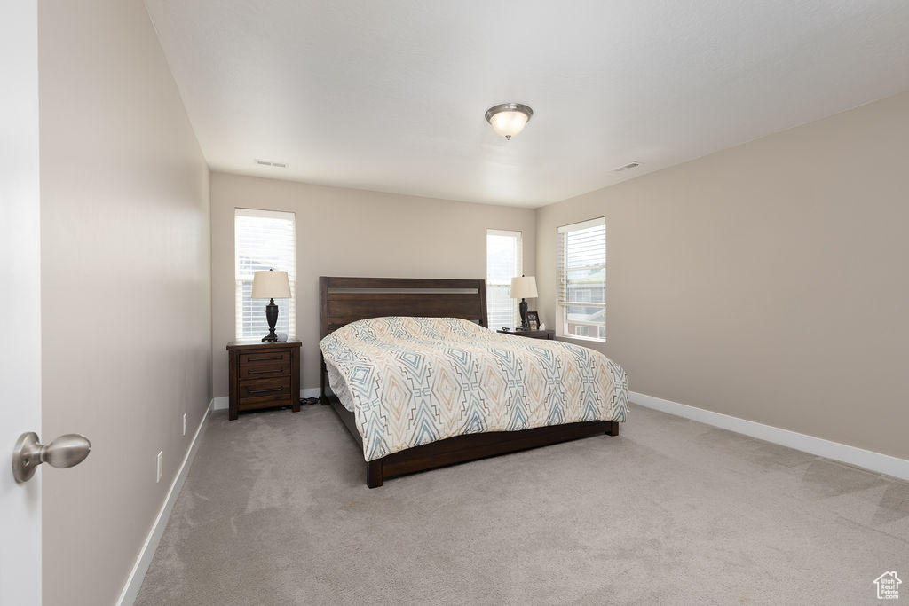 Bedroom with visible vents, carpet floors, and baseboards