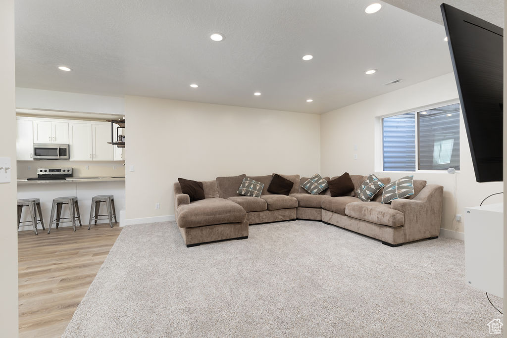 Living area featuring recessed lighting, light wood finished floors, and baseboards