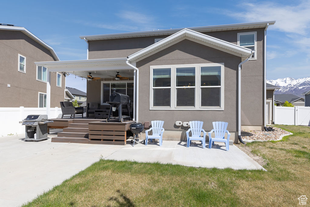 Back of house with a patio, ceiling fan, stucco siding, and fence
