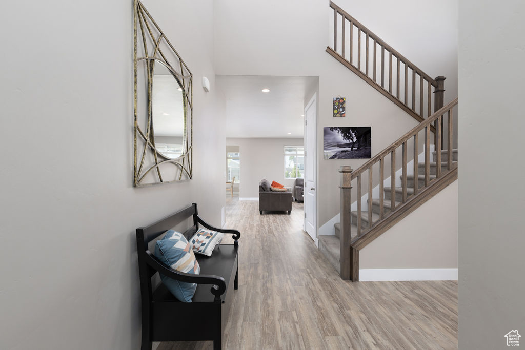 Entryway featuring stairway, wood finished floors, a high ceiling, and baseboards
